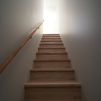 階段は外部からの間接的な柔らかい光で照らし、陰影を作り出しています。